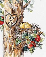 Birds of a Feather/ Carving Tree feature Two loving birds snuggled in their nest on a tree. Are those their initials carved in the trunk next to the nest? Counted Cross Stitch Design by Nancy Rossi.